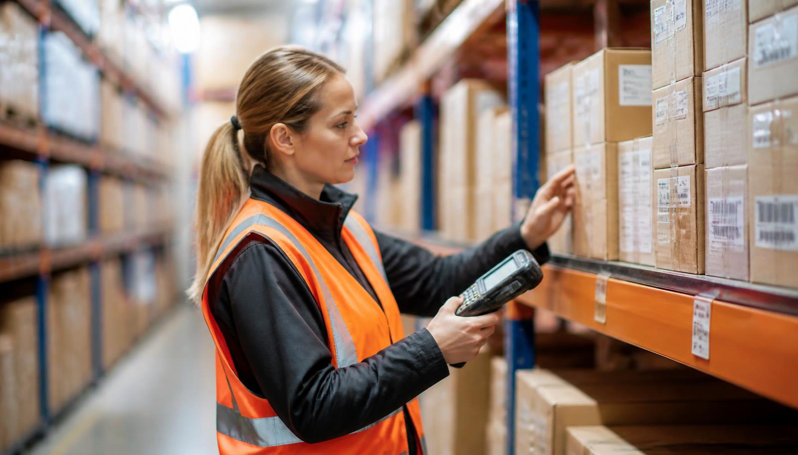 Warehouse operator cycle counting boxes on a rack with an RF handheld terminal